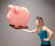 Young girl holding a huge savings piggy bank