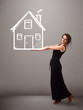 Photo: Young lady holding a huge drawn house Young lady holding a huge drawn house