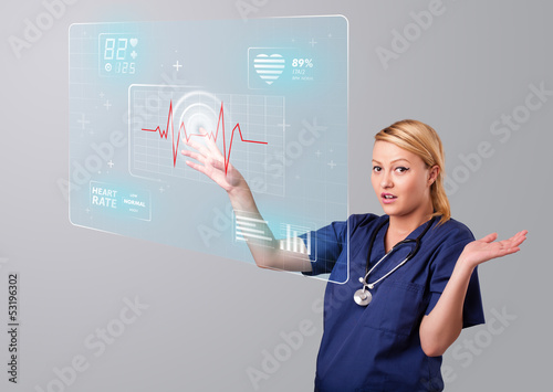 Photo: Young nurse pressing modern medical type of buttons Young nurse pressing modern medical type of buttons
