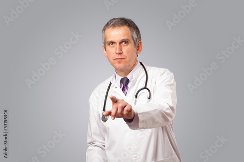 Photo: Middle aged doctor gesturing with copy space Middle aged doctor gesturing with copy space
