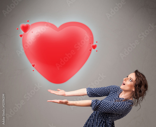 Photo: Young lady holding lovely 3d red heart Young lady holding lovely 3d red heart