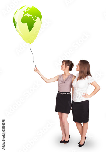 Photo: Happy ladies holding a green globe balloon Happy ladies holding a green globe balloon