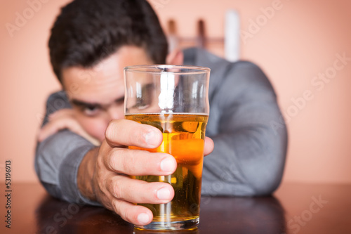 Photo: Drunk hispanic man holding a glass of beer Drunk hispanic man holding a glass of beer