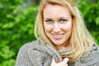 Photo: Portrait of smiling woman in grey hand-knitted jacket Portrait of smiling woman in grey hand-knitted jacket