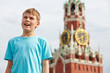Portrait of boy in blue t-shirt against Spassky tower of Moscow