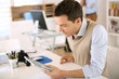 Photo: Handsome guy working with tablet in office Handsome guy working with tablet in office