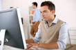 Man working in office in front of desktop computer