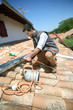 Roofer working on house roof to fix gutter