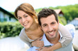 Photo: Cheerful couple standing in front of new house Cheerful couple standing in front of new house