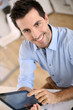 Upper view of smiling man using digital tablet