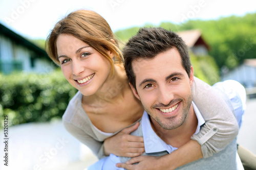 Photo: Cheerful couple standing in front of new house Cheerful couple standing in front of new house