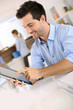 Smiling man in office working on digital tablet