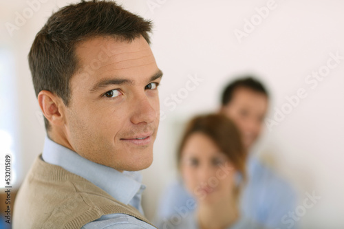 Photo: Handsome man standing in front of business team Handsome man standing in front of business team