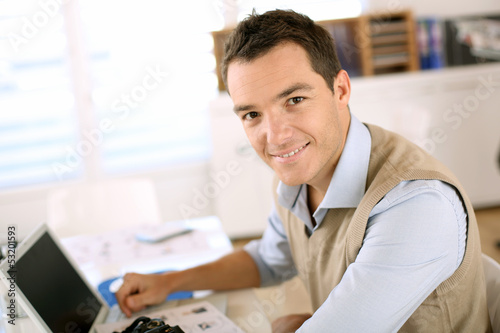 Photo: Portrait of smiling man sitting in office Portrait of smiling man sitting in office