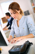 Photo: Young woman in office working on desktop Young woman in office working on desktop