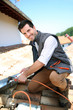 Roofer working on house roof to fix gutter