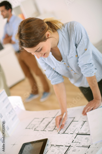 Photo: Young woman architect working in office Young woman architect working in office