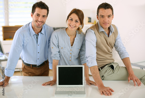 Photo: Successful startup people showing laptop screen Successful startup people showing laptop screen
