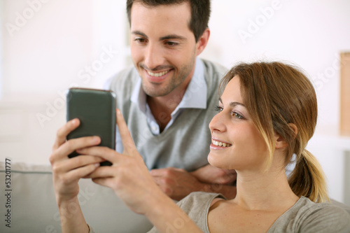 Photo: Young people at home using smartphone Young people at home using smartphone