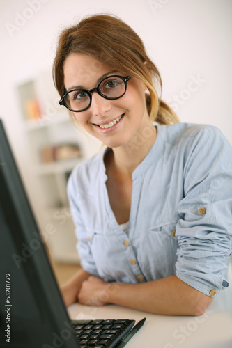 Photo: Girl with eyeglasses working in office Girl with eyeglasses working in office