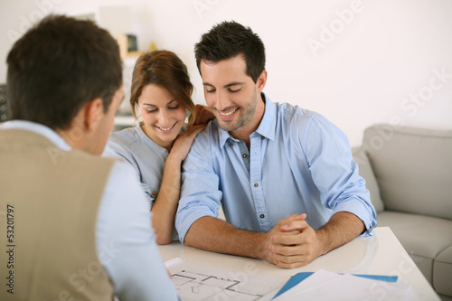 Photo: Young couple meeting architect for future house Young couple meeting architect for future house