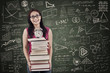 Asian female student bring stack of books in class