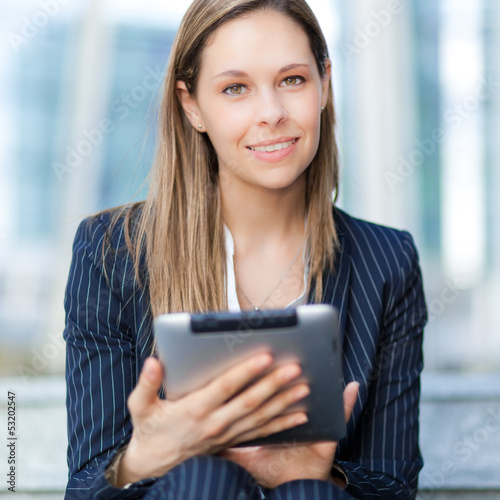Photo: Beautiful businesswoman using a digital tablet Beautiful businesswoman using a digital tablet