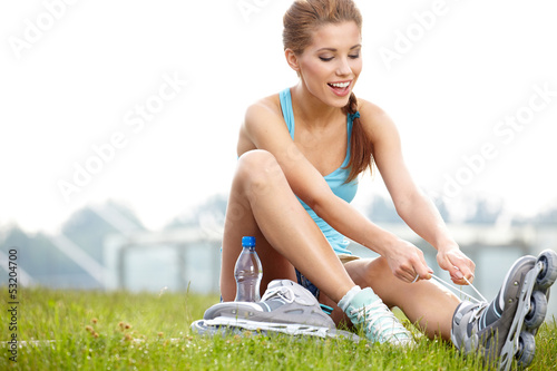 Photo: young woman skating with rollerblades in a park young woman skating with rollerblades in a park