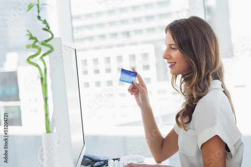 Photo: Cheerful designer purchasing online Cheerful designer purchasing online