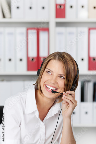 Photo: Laughing businesswoman talking on headset Laughing businesswoman talking on headset