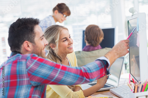 Photo: Designer pointing at the screen of a colleague Designer pointing at the screen of a colleague