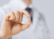 Photo: doctor hand showing one capsule doctor hand showing one capsule