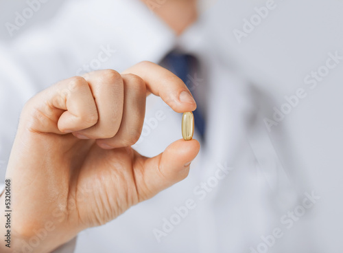 Photo: doctor hand showing one capsule doctor hand showing one capsule