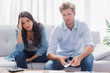 Photo: Couple looking anxious while doing their accounts Couple looking anxious while doing their accounts