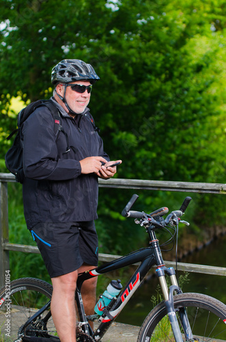 Photo: radfahrer tippt auf handy radfahrer tippt auf handy
