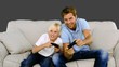 Video: Father and son playing video games on grey background Father and son playing video games on grey background