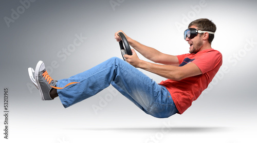 Photo: Funny bearded man car driver in goggles with a wheel Funny bearded man car driver in goggles with a wheel