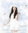 Beautiful brunette woman in white dress and hat