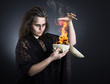 Foto: A witch casts a spell with a skull. A witch casts a spell with a skull.