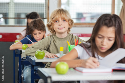 Photo: Schoolboy Sitting At Desk With Classmates In A Row Schoolboy Sitting At Desk With Classmates In A Row