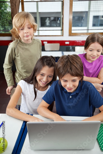 Photo: Schoolchildren Using Laptop At Desk Schoolchildren Using Laptop At Desk