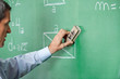 Foto : Male Professor Cleaning Greenboard With Duster Male Professor Cleaning Greenboard With Duster