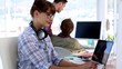 Video: Designer working on her laptop and looking at camera Designer working on her laptop and looking at camera