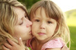 Mama and her little daughter  on grass