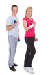 Photo: Portrait Of Couple Exercising With Dumbbells Portrait Of Couple Exercising With Dumbbells