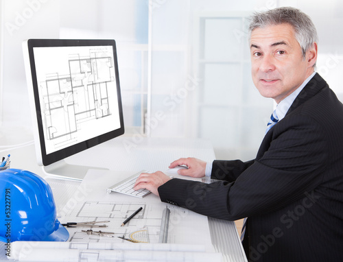 Photo: Mature Architect Male Working At The Desk Mature Architect Male Working At The Desk