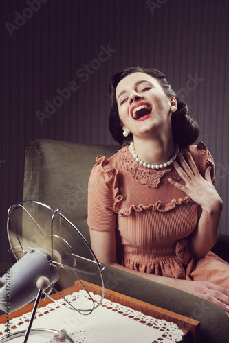 Photo: Woman cooling herself with fan Woman cooling herself with fan