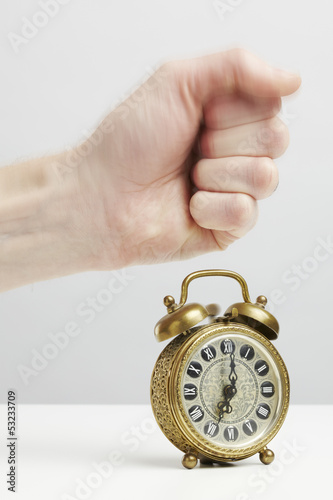 Photo: Hand stopping alarm on clock Hand stopping alarm on clock