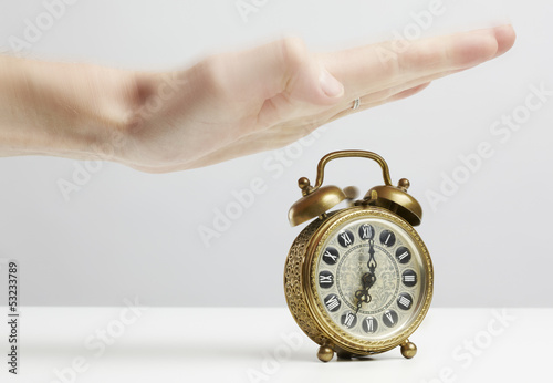 Photo: Hand stopping alarm on clock Hand stopping alarm on clock