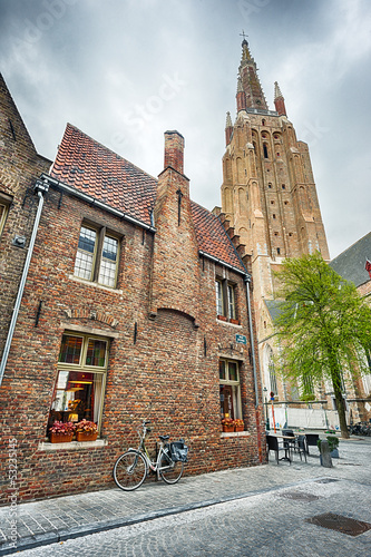 Photo: Old brick building, paved street and high church Old brick building, paved street and high church